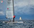 A Class Cat Worlds at Punta Ala - US Classic sailor Bob Webbon, USA 165, looks at the schooner and the impending storm © Gordon Upton / www.guppypix.com