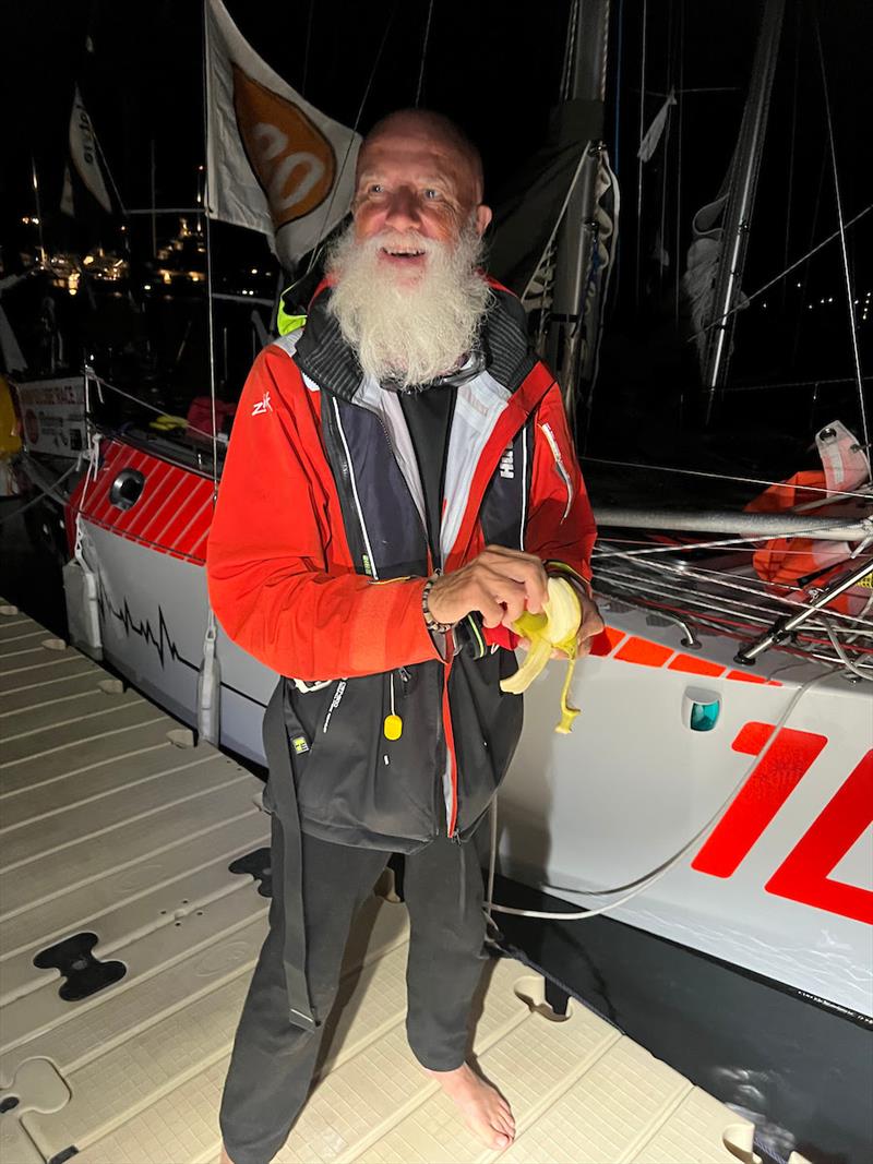 Mike Blenkinsop, AKA Popeye, enjoying a fresh Banana on arrival to celebrate his 70th Birthday. Over half the fleet were completely bored with their food catering arrangements for the voyage across the Atlantic, most hardly lit their stoves - photo © Don McIntyre / CG580T/ MGR2025