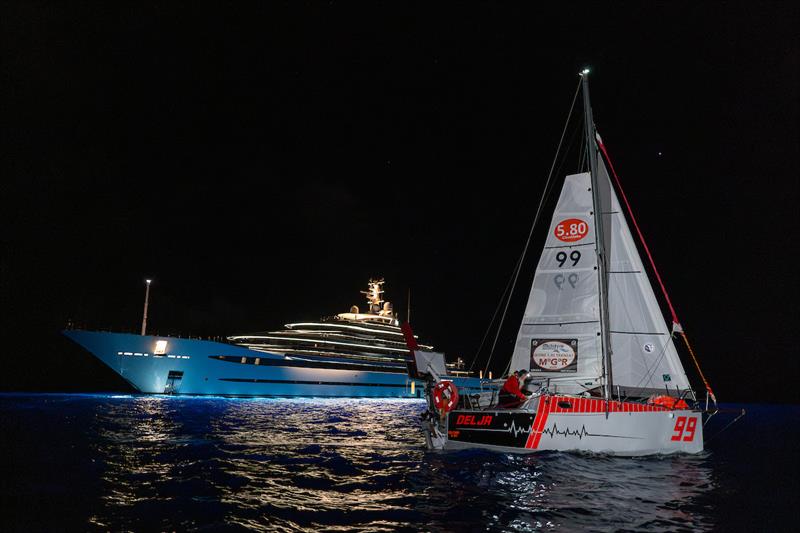 Mike Blenkinsop, AKA Popeye, onboard Delja99 was welcomed by one of the many mega yachts in Antigua photo copyright Rob Havill / G580T/ MGR2025 taken at  and featuring the Class Mini 5.80 class