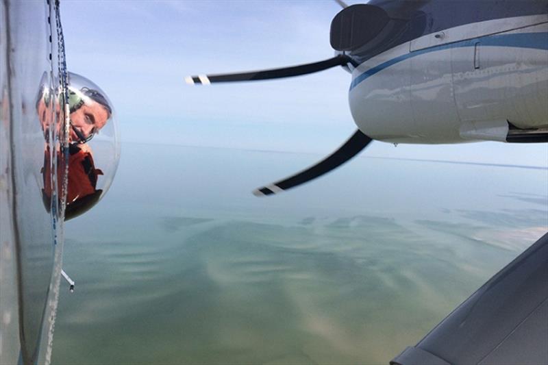 Aerial survey observer scans for whales from airplane bubble window photo copyright NOAA Fisheries / Christin Khan taken at  and featuring the Environment class