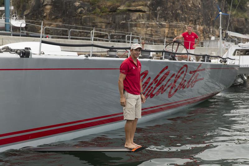 Wild Oats XI crewman, Nathan Ellis, shows off the yacht~s radical new carbon fibre, hydrofoil wing - photo © Andrea Francolini