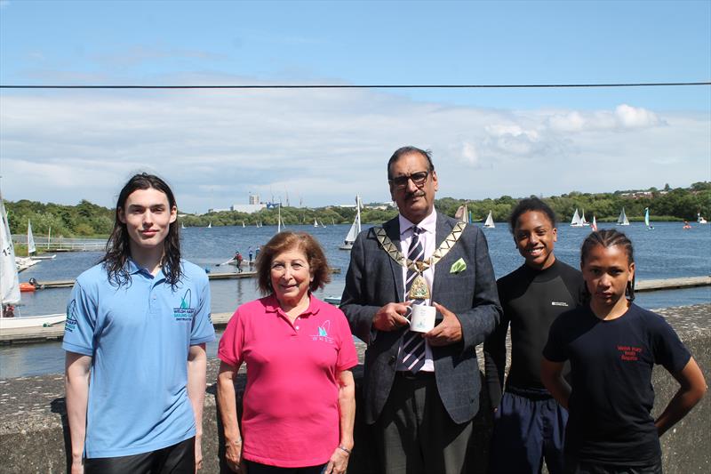 Brent Regatta 2024: A moment of sunshine, the regatta in the background. Junior Instructor Nico, Social Secretary Vivien, Mayor of Brent Tariq Dar, Juniors Alex & Zach photo copyright Anita Whittaker, Welsh Harp Sailing Club taken at Welsh Harp Sailing Club